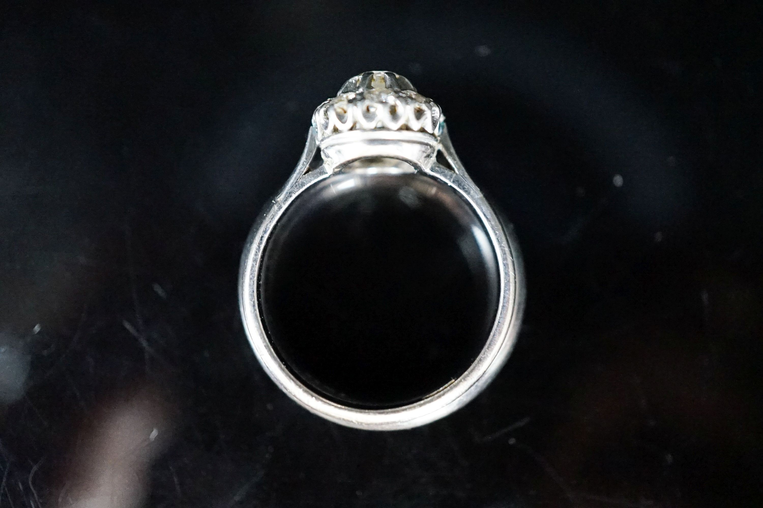 A modern 18ct white gold and diamond cluster ring, now soldered together with an 18ct white metal band, size P, gross weight 12.9 grams.